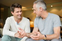 Two male friends discussing and smiling — Stock Photo