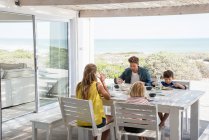 Giovane famiglia godendo il cibo in veranda — Foto stock