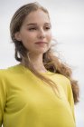 Close-up of thoughtful teenage girl in yellow sweater — Stock Photo