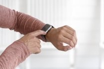 Primer plano de las manos masculinas comprobar smartwatch - foto de stock