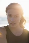 Портрет чуттєвої молодої жінки, що стоїть на пляжі на сонячному світлі — стокове фото