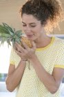 Крупним планом жінка пахне свіжим ананасом — стокове фото