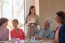 Felices abuelos celebrando cumpleaños con nietos en casa - foto de stock