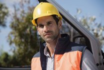 Портрет инженера-мужчины в шлеме, стоящего у фургона — стоковое фото