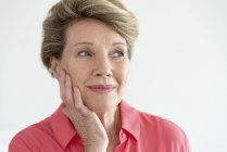 Close-up of happy senior woman thinking with hand on face — Stock Photo