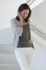 Thoughtful mature woman standing on staircase — Stock Photo