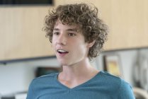 Portrait of amazed teenage boy with curly hair — Stock Photo