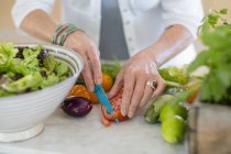 Nahaufnahme weiblicher Hände beim Schneiden von Gemüse in der Küche — Stockfoto