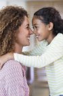 Happy mother and daughter rubbing noses — Stock Photo