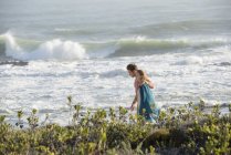 Couple romantique marchant sur la côte avec tempête sur fond — Photo de stock