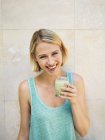 Портрет улыбающейся здоровой женщины, пьющей детоксикацию — стоковое фото