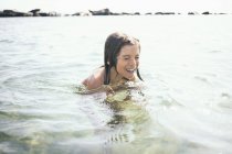 Boy with long hair swimming in lake — Stock Photo