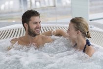 Portrait of relaxed laughing couple resting in hot tub — Stock Photo