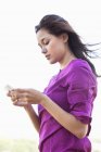 Jovem mulher lendo mensagem de texto no celular — Fotografia de Stock