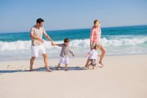 Familia disfrutando de vacaciones en la playa - foto de stock