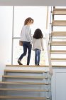 Счастливые мать и дочь идут по лестнице — стоковое фото