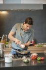 Человек готовит еду на современной кухне — стоковое фото