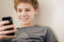 Adolescent garçon en utilisant téléphone — Photo de stock