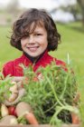 Menino feliz segurando caixa de legumes caseiros no campo — Fotografia de Stock
