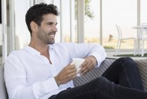 Homme heureux dégustant une tasse de café sur la terrasse — Photo de stock