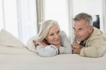 Thoughtful senior couple resting on bed at home — Stock Photo