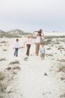 Casal andando na praia com seus filhos — Fotografia de Stock
