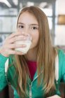 Портрет дівчини-підлітка, що п'є молоко — стокове фото
