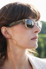 Close-up de mulher elegante séria usando óculos de sol olhando para longe — Fotografia de Stock