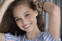Retrato de menina adolescente sorridente com as mãos no cabelo — Fotografia de Stock