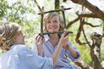 Kinder basteln Rahmen aus Treibholz im Freien — Stockfoto