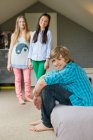 Хлопчик-підліток з двома сестрами посміхається вдома — стокове фото
