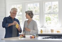 Glückliches Seniorenpaar bereitet Essen in Küche zu — Stockfoto