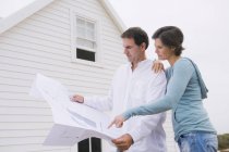 Konzentriertes älteres Paar schaut sich Bauplan des Hauses an — Stockfoto