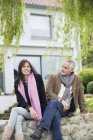 Couple romantique souriant assis dans le jardin à la campagne — Photo de stock
