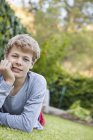 Porträt eines Teenagers, der auf Gras liegt — Stockfoto