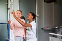 Female nurse assisting to a girl patient in hospital — Stock Photo