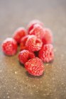 Close-up of fresh red raspberries in heap on brown background — Stock Photo