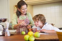 Grandmother and little boy cooking food at kitchen — Stock Photo