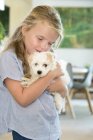 Portrait of cute little girl holding puppy — Stock Photo