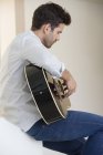 Relaxed man in white shirt playing a guitar — Stock Photo