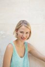 Porträt einer lächelnden blonden Frau im Tank-Top gegen geflieste Wand — Stockfoto