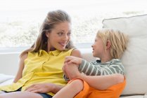 Happy mother and son sitting on couch in living room — Stock Photo