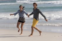 Portrait of happy cheerful young couple having on summer beach — Stock Photo