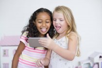 Smiling little girls taking selfie with camera phone — Stock Photo