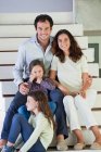 Coppia con i loro figli seduti su gradini — Foto stock