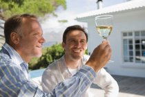 Zwei Freunde blicken auf ein Weinglas — Stockfoto