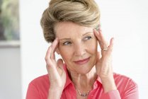 Nahaufnahme einer glücklichen Seniorin mit dem Kopf in den Händen — Stockfoto