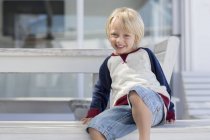 Portrait de petit garçon heureux aux cheveux blonds souriant à l'extérieur — Photo de stock