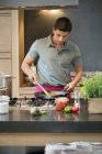 Mann bereitet zu Hause in Küche Essen zu — Stockfoto