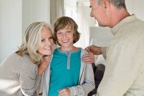 Grandparents hugging their grandson at home — Stock Photo